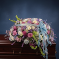 Casket with a floral arrangement on a dark background