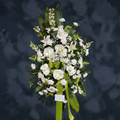Bouquet of white flowers with green leaves and ribbons on a dark background